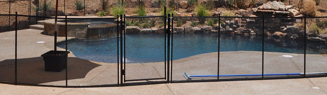 Self-locking pool safety gate installed around backyard pool